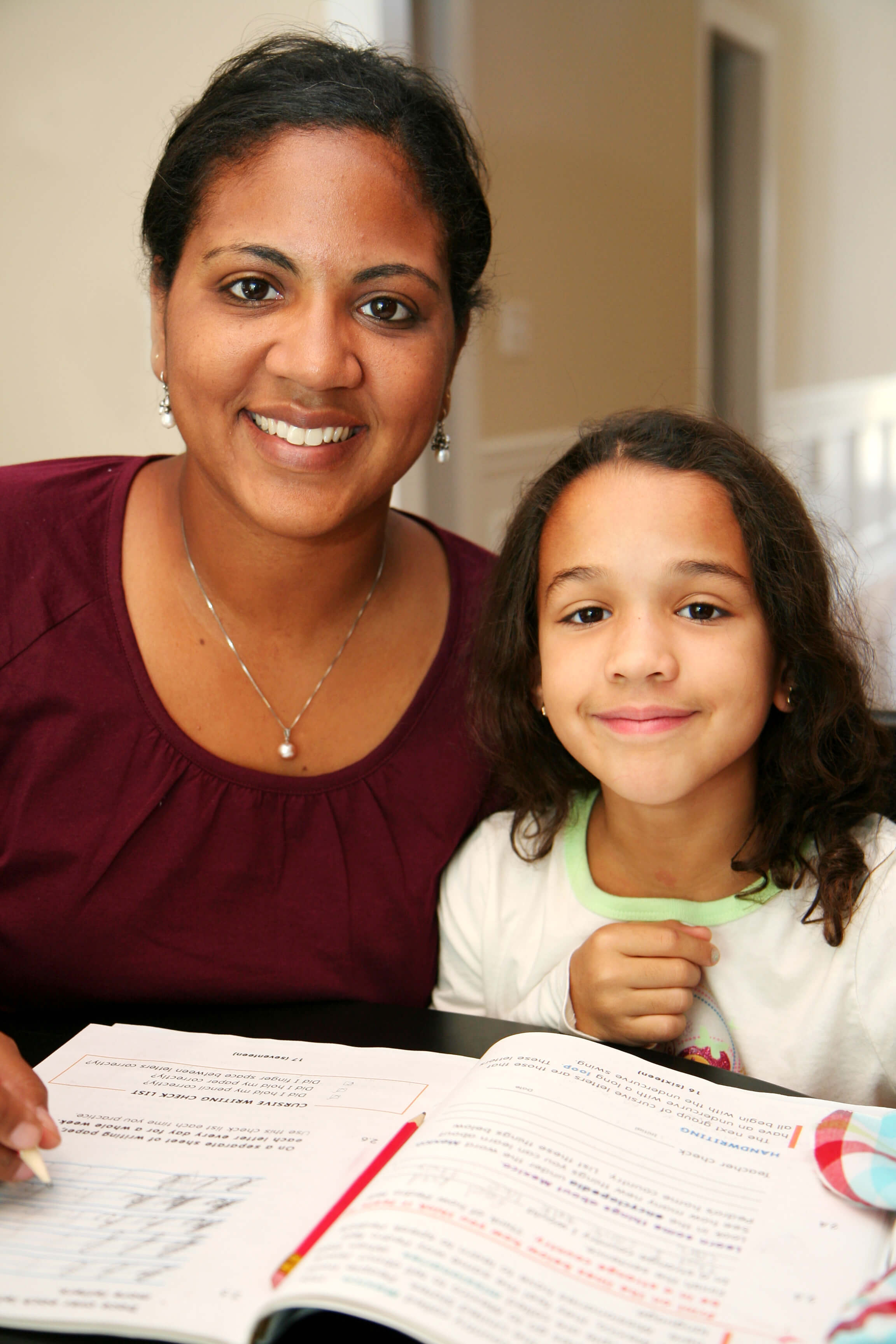 tutrice et eleve souriantes pendant aide aux devoirs