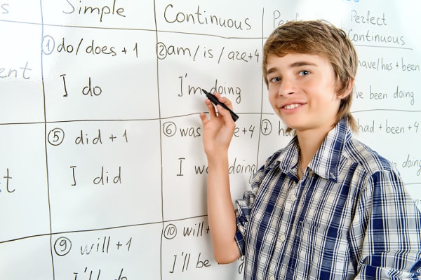 cours d'anglais élève qui fait exercices au tableau blanc