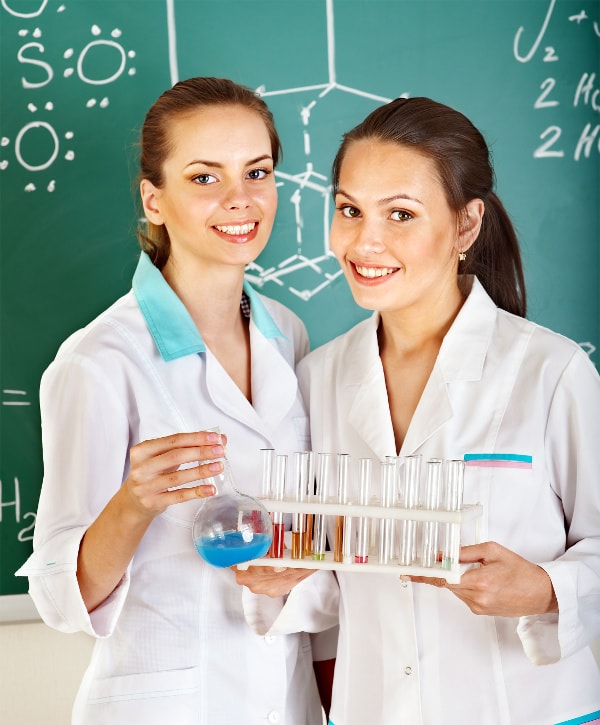 2 élèves du secondaire font des expériences de chimie à l'école